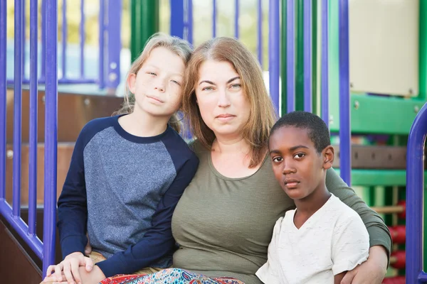 Mulher adulta sentada com dois meninos — Fotografia de Stock
