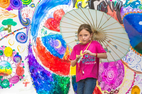Dívka nesoucí deštník na festivalu divoké husy — Stock fotografie