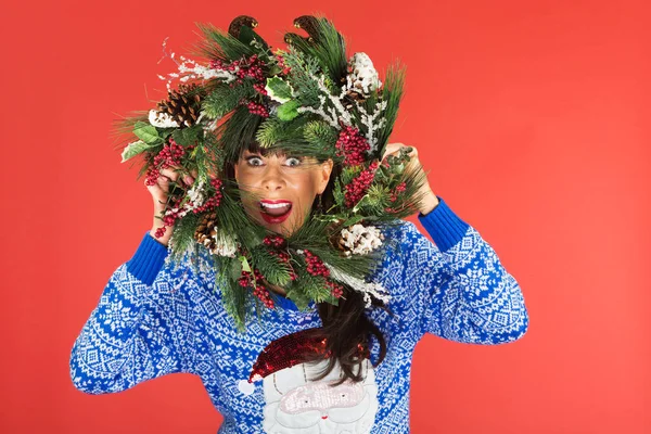 Vrouw op zoek door middel van de kroon van Kerstmis — Stockfoto