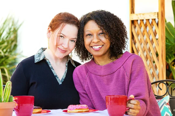 Mixed lesbian couple sitting at table — Stock Photo, Image