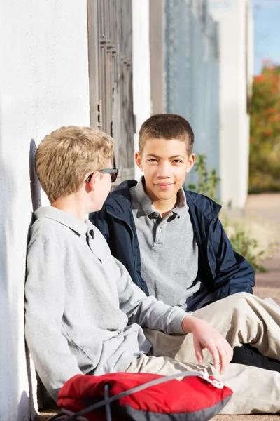 Två unga män vänner sitter utanför — Stockfoto