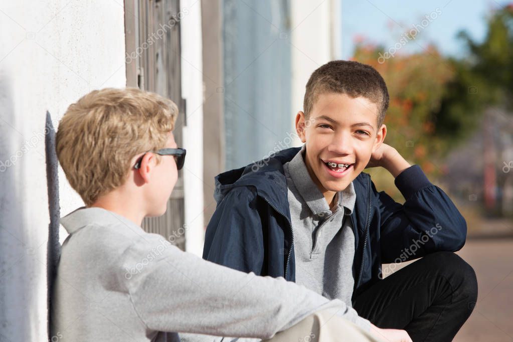 Laughing teen with braces outside with friend