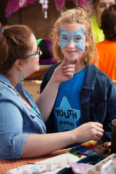 Girl with butterfly makeup smiling at camera — Stock Photo, Image