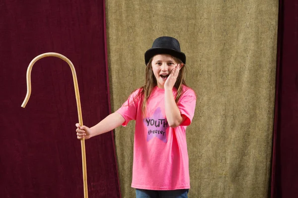 Girl in hat with staff posing — Stock Photo, Image