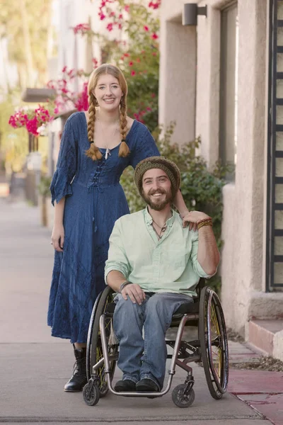 Женщина с косичками и мужчина в инвалидном кресле — стоковое фото