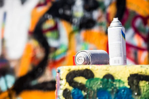 Two Discarded Spray Cans in Front of Graffiti Wall — Stock Photo, Image