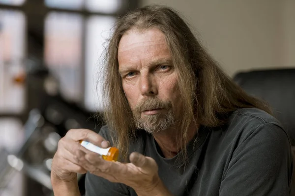 Uomo con una bottiglia di pillola di prescrizione oppioide — Foto Stock