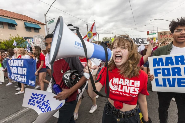 Mujer joven liderando multitud con megáfono en protesta por violencia armada —  Fotos de Stock