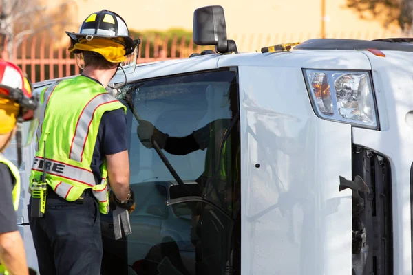 Emergency Responders Cracking Window on Mini Van with Halligan B Stock Picture