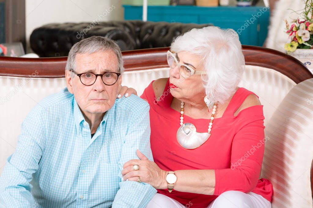 Concerned Senior Man on Couch with Partner