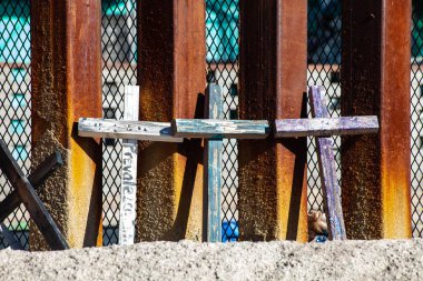Memorial Crosses Leaning Against Border Wall with Mexico Seeing  clipart