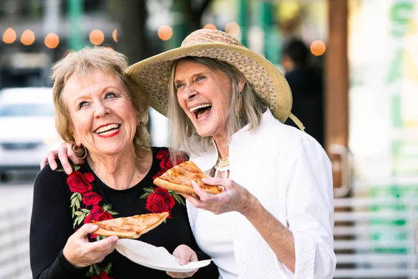 Idős nők utcai kaját esznek és nevetnek — Stock Fotó