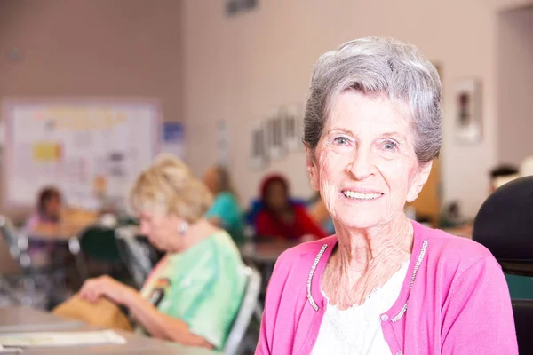 Plan horizontal d'une femme souriante dans un centre pour personnes âgées Image En Vente