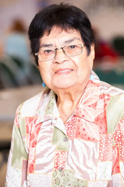 Smiling Latina woman in a busy senior center