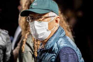 SEVILLE, SPAIN - 7 Mart: kendini ve diğerlerini koronavirüsten korumak için maske takan tanımlanamayan adam. 7 Mart 2020 Sevilla, İspanya. 