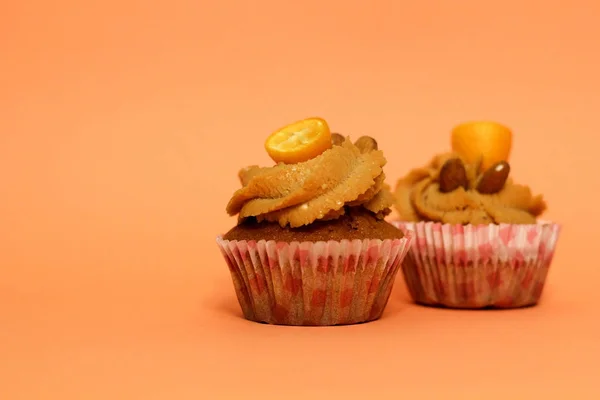 Krém karamell cupcake mandula díszített narancssárga háttér — Stock Fotó