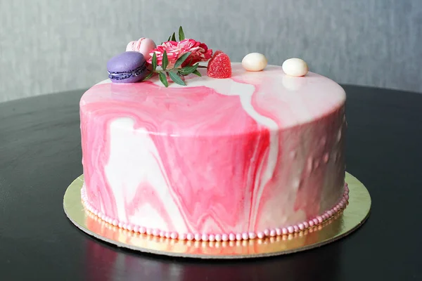 Smakelijke roze zelfgemaakte taart gedecoreerd door rose en macarons — Stockfoto
