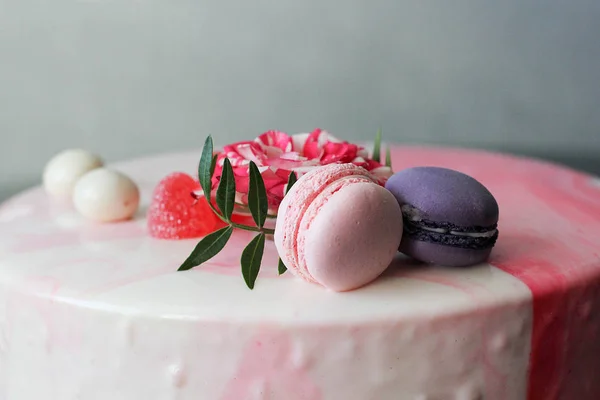 Smakelijke roze zelfgemaakte taart gedecoreerd door rose en macarons — Stockfoto