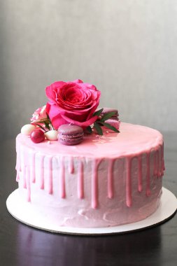 Rose ve macarons tarafından dekore edilmiş lezzetli pembe ev yapımı kek