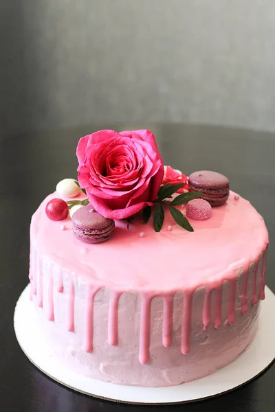 Bolo caseiro rosa saboroso decorado por rosa e macarons — Fotografia de Stock