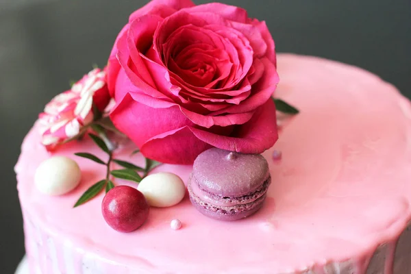 Sabroso pastel hecho en casa rosa decorado con rosa y macarrones — Foto de Stock