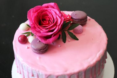 Rose ve macarons tarafından dekore edilmiş lezzetli pembe ev yapımı kek
