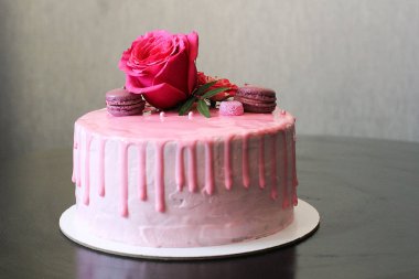 Rose ve macarons tarafından dekore edilmiş lezzetli pembe ev yapımı kek