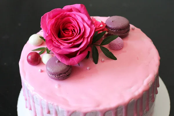 Läckra rosa hemmagjord tårta dekorerad av rose och macarons — Stockfoto