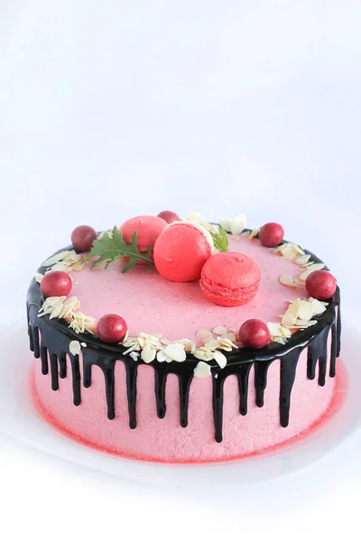 Smakelijke roze zelfgemaakte cake versierd met rode snoepjes — Stockfoto