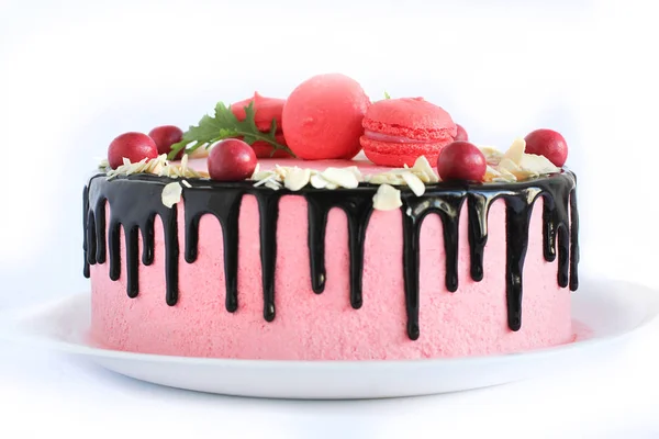 Smakelijke roze zelfgemaakte cake versierd met rode snoepjes — Stockfoto