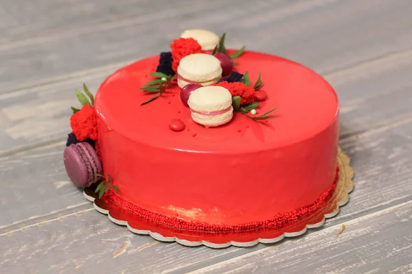 Смачний червоний домашній торт, прикрашений червоними цукерками та макарони — стокове фото