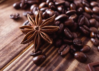 Kahve çekirdeğine yakın çekim, anis ahşap kahverengi masada. İnsansız Düz Yat