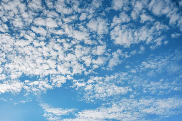 white cirrus, feathery clouds  against spring bright blue cloudy sky  on sunny day in England