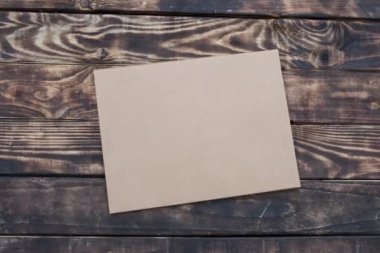 Bir el işi zarf, içine beyaz kağıt ve eski kahverengi ahşap masa üzerinde siyah kalem.