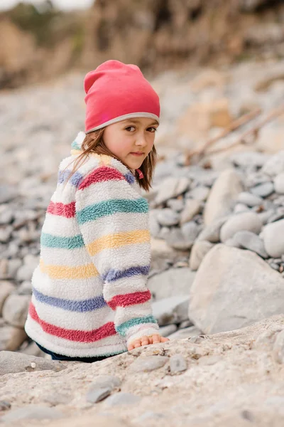 Счастливая Молодая Девушка Красочном Пальто Розовая Шляпа Черные Брюки Сидят — стоковое фото