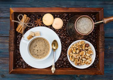 Bir fincan kahve, kabın içinde fındık, kahve, tarçın, anason, şeker, ahşap tepside kahve. İnsansız Düz Yat. Yukarıdan görüntüle.