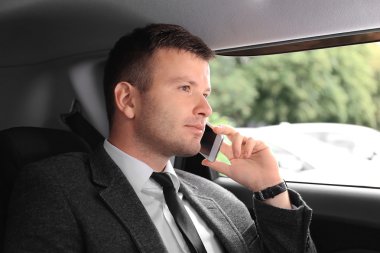 Bir arabada cellphone tarafından konuşan işadamı