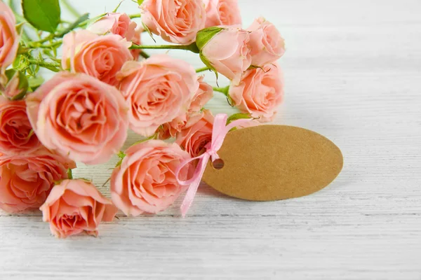 Rose fresche e carta su sfondo di legno — Foto Stock