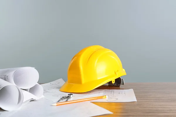 Planos de construcción con herramientas y casco sobre fondo claro —  Fotos de Stock