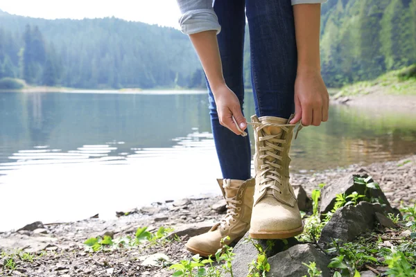 Fille attacher lacets sur la rive de la rivière — Photo