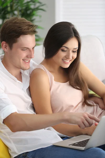 Beautiful couple surfing internet on laptop at home — Stock Photo, Image