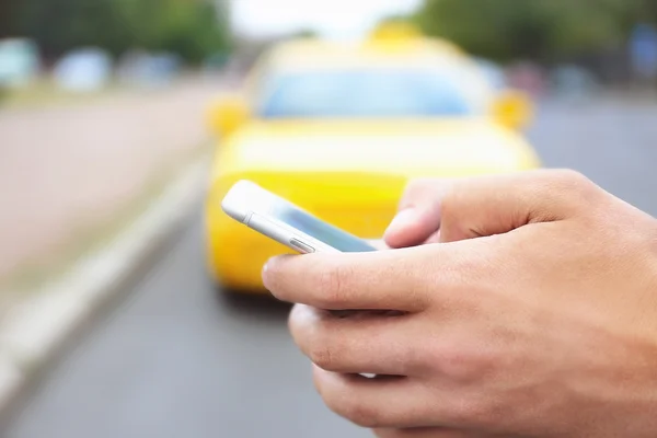 Рука з мобільним телефоном виклик таксі — стокове фото