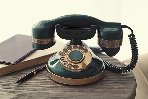 Винтажный телефон на деревянном столе — стоковое фото