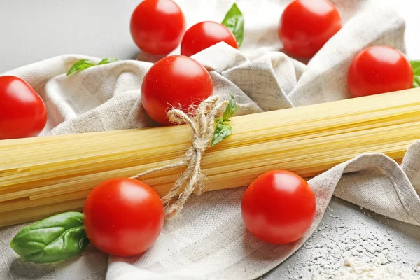 Pasta seca de espagueti con tomates cherry en la mesa —  Fotos de Stock