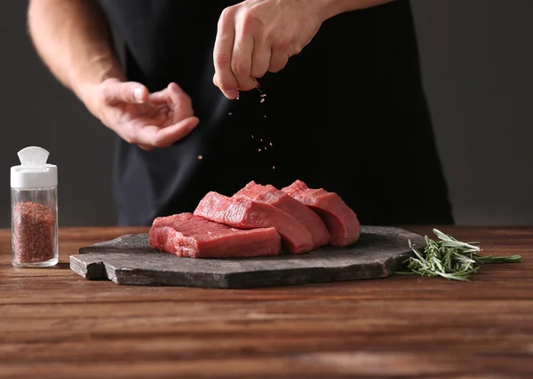 Butcher cooking pork meat