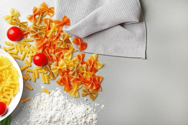 Teller mit verschiedenen Nudelsorten mit Kirschtomaten auf dem Tisch — Stockfoto