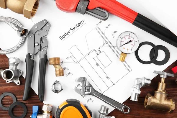 Plumbing tools with house plan on wooden background — Stockfoto