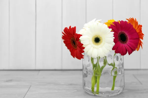 Bellissimi fiori di gerbera in vaso su fondo di legno sfocato — Foto Stock