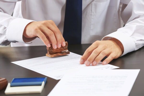 Нотариус в офисе штамповка документа
