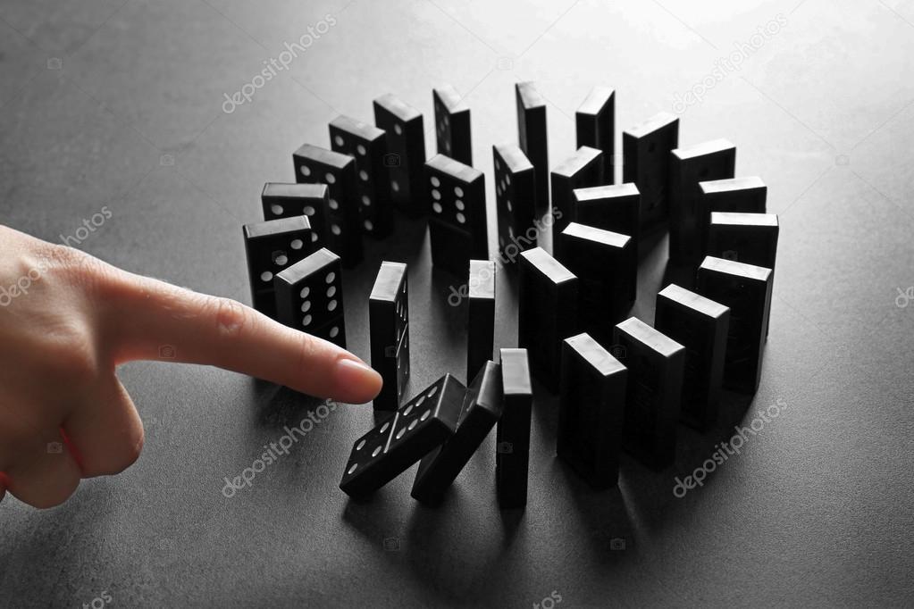 hand pushing dominoes 